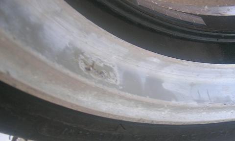 [The front wheel showing the discoloration, some cracking in the clearcoat, and the overall weathered and abused appearance..]